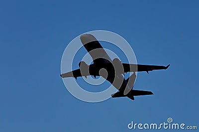 A large modern plane flies in the sky, a view from below from the ground to the belly of the aircraft. Stock Photo