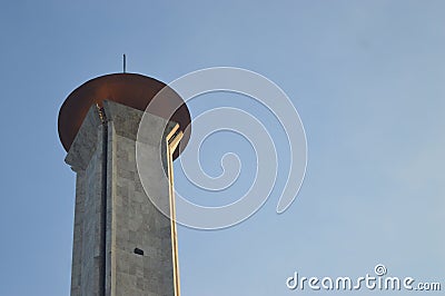 A large mosqoe tower with a blue sky behind it Stock Photo