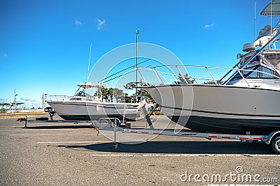 Large motor boats on car trailers parked at the pier Stock Photo