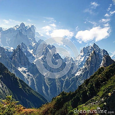 Large mountains with forest clearings into which clouds crash Stock Photo