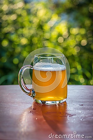 Large mug of beer on table outside Stock Photo