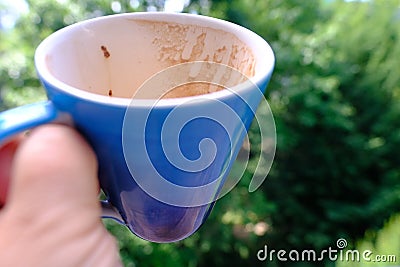 large mug with drips of coffee on walls in woman's hand, drunk coffee, divination or fortune-telling method that interprets Stock Photo