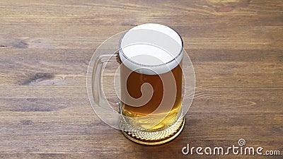 A large mug of light tasty cold beer on a wooden table, close-up, Stock Photo