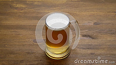 A large mug of light tasty cold beer on a wooden table, close-up, Stock Photo