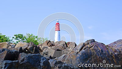Large Natural Rocks Set Against The Lighthouse Tower Of Tanjung Kalian Stock Photo