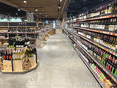 A large number of bottles of wine lying in a showcase in a supermarket Editorial Stock Photo
