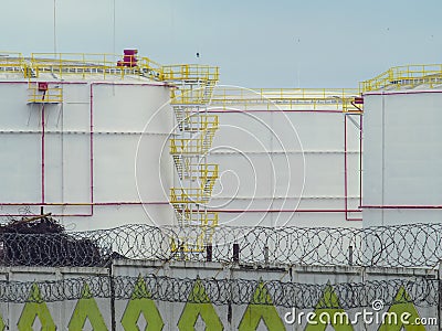 Large oil tanks in a fenced area Stock Photo