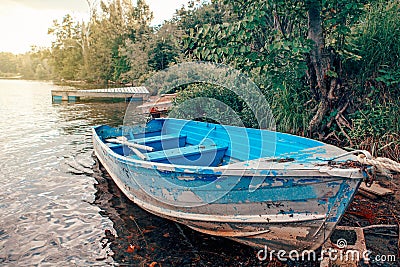 Large old blue boat and two paddles on shore beach. Beautiful landscape sunset view at Canadian Ontario Beech lake in Muskoka area Stock Photo