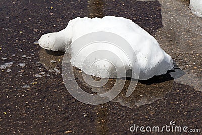 A large pile of dirty white snow lies on the asphalt road Stock Photo