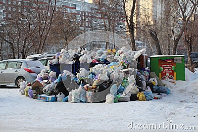 A large pile of plastic bags of garbage and household waste in the city dump in the winter in Novosibirsk pollutes the environment Editorial Stock Photo