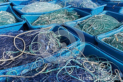 Large plastic tubs filled with industrial size fishing and trawling nets used in the offshore fishing industry Stock Photo