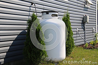 A large propane tank on the side of a house Stock Photo