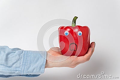 Large red bell pepper, Googly eyes on palm. Scared pepper character. White background Stock Photo