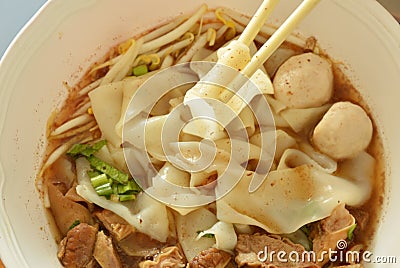 Large rice noodle with braised pork in soup picking by chopsticks Stock Photo