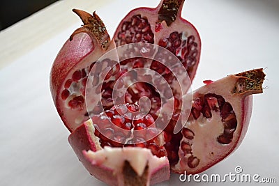 Large ripe red pomegranate cut into four lobes. Stock Photo