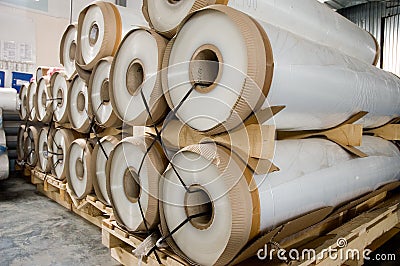 Large rolls of transparent polyethylene lie on a pallet. Stock Photo