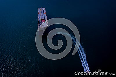 Large RoRo carrier vessel and tug boat sailing on the sea dramatic Stock Photo