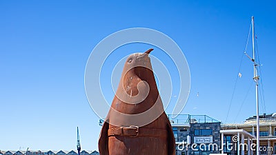 Large rusty penguin statue standing next to the bridge crossing at the Waterfront in Cape Town. Editorial Stock Photo