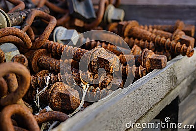 Large rusty screws in a wooden box Stock Photo