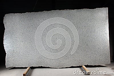 A large slab of natural gray stone with dark dots is called granite Bianco Cristall Stock Photo