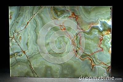 A large slab of natural green stone with red veins is called Verde Onix Stock Photo