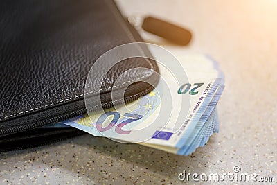 Large stack of money worth 20 euros are stick out of the purse. Toned image Stock Photo