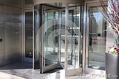 A large stainless steal and glass revolving door in front of an office building in downtown Atlanta Editorial Stock Photo
