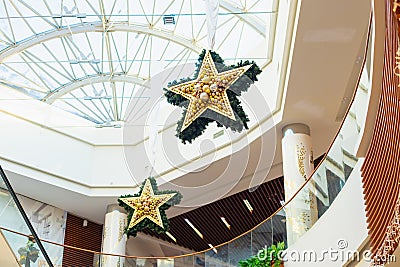 Large stars New Year Christmas decor in shopping mall interior, glass roof atrium. Pavlodar, Kazakhstan - 01.17.2023 Editorial Stock Photo