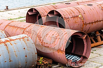 Large steel ducts and pipes rusty and abandoned in the harbour Stock Photo