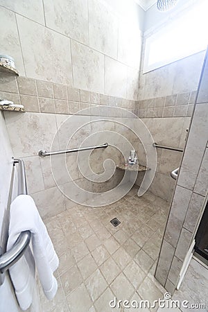 A large tiled handicap accessible shower with handrails Stock Photo