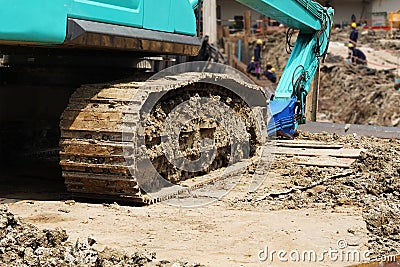 Large tracked excavator ,Excavator tractor pours the soil with Construction workers and construction engineer wearing safety Stock Photo