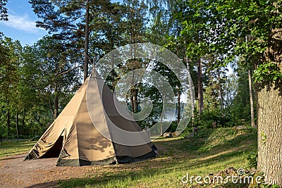 A large traditional teepee tent with luxurious glamping interior provides alternate but comfortable lodging for outdoor adventurer Stock Photo