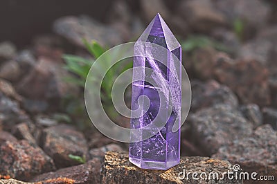 Large transparent mystical faceted crystal of colored lilac amethyst, chalcedony on a stone background close-up. Wonderful mineral Stock Photo