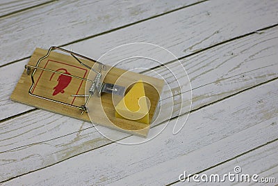 Triangular piece of cheese in mousetrap Stock Photo