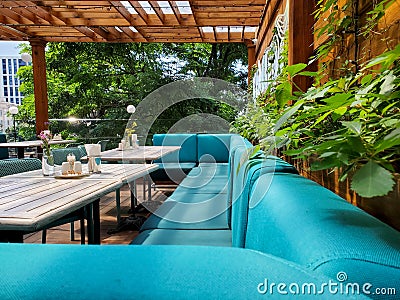 Large turquoise sofa and table on the terrace, cozy outdoor dining area Stock Photo