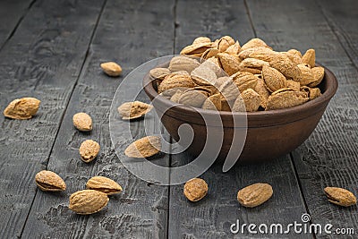 Large unpeeled almonds in a deep bowl on the table Stock Photo