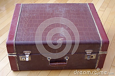 Retro brown closed suitcase on wooden floor Stock Photo