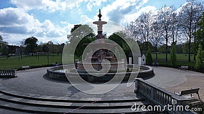 Large water fountain in the park against a backdrop of steps, grass, and trees Stock Photo