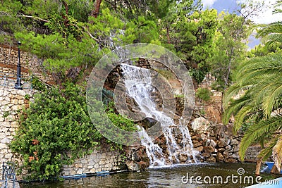 A large waterfall with radon water among boulders at the foot of a mountain in Loutraki, Greece Stock Photo