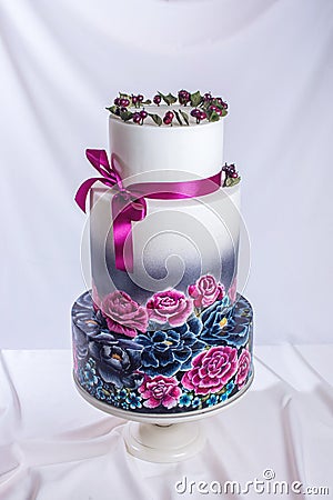 Wedding cake ornamented in rustic style blue and purple roses Stock Photo