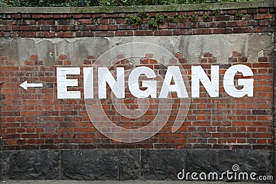 Text EINGANG on the brick wall which means EXIT in german Stock Photo