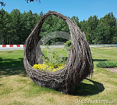 Large wicker baskets of brushwood with beautiful yellow flowers by the road Stock Photo