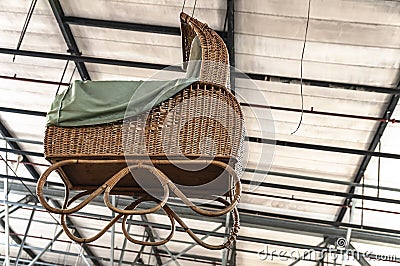 Large wicker pram hangs from the ceiling Stock Photo