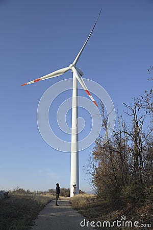 Large wind turbines with man. Production of clean and renewable energy. Trentino, Italy Editorial Stock Photo