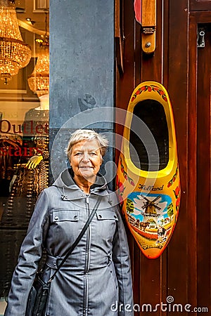 Large wooden shoe, painted in traditional Dutch pattern and colors, hanging outside souvenir shop in Amsterdam Editorial Stock Photo
