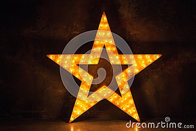 Large wooden star with a large amount of lights in front of dark concrete background. Stock Photo