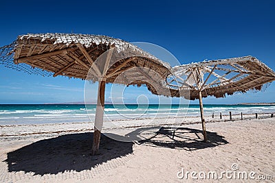 Large wooden umbrellas at sandy tropical beach Stock Photo