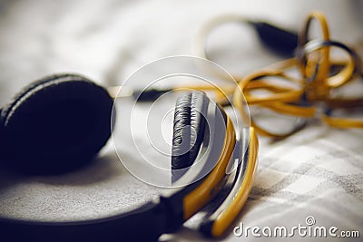 Large yellow headphones lie on a gray plaid Stock Photo