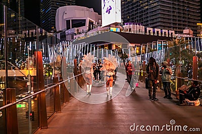 LAS VEGAS - November 11, 2020, a girl's feather stands on a night street illuminated by multi-colored lights, Las Vegas Editorial Stock Photo