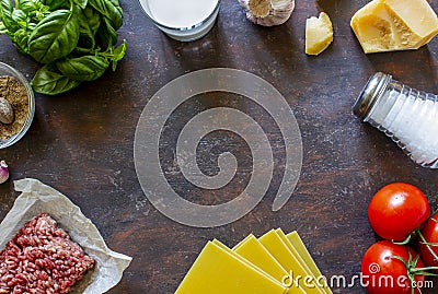 Lasagna, tomatoes, minced meat and other ingredients. Dark background. Italian cuisine Stock Photo